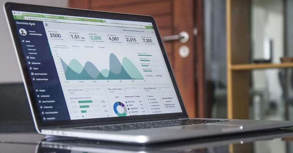 "An open laptop displaying a detailed dashboard with data visualizations, including line graphs, bar charts, and metrics such as user statistics and engagement rates. The interface highlights analytics for tracking performance and trends. The background features a modern office environment, adding a professional context to the setup."